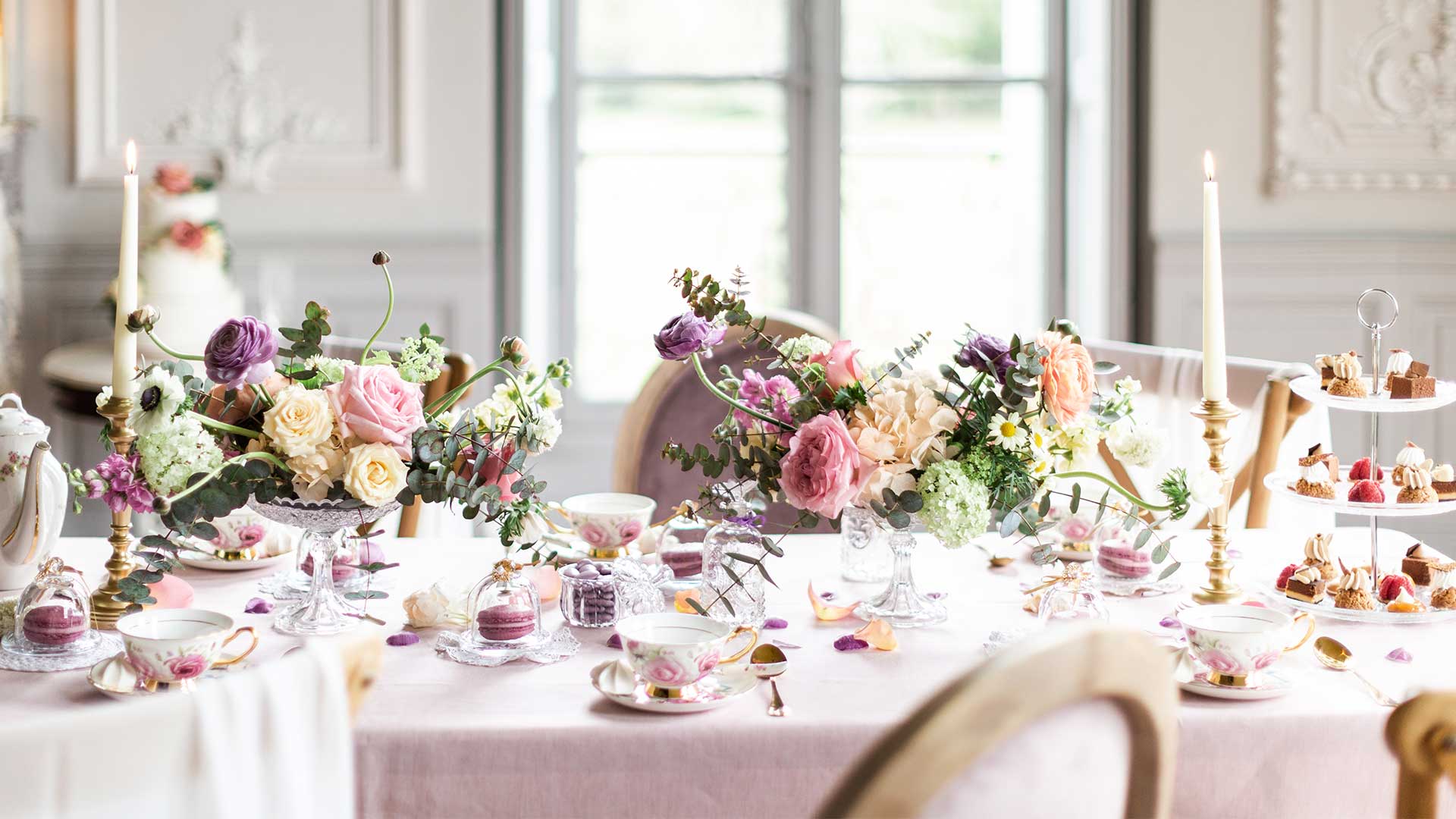 table avec nappe blanches, roses et décorations pour un mariage